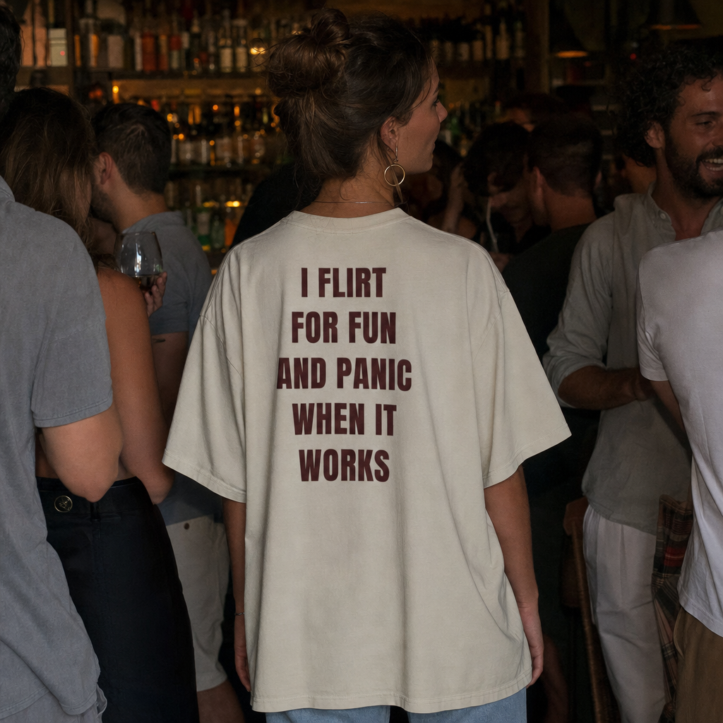 I Flirt for Fun and Panic When It Works oversized tee worn in a busy bar