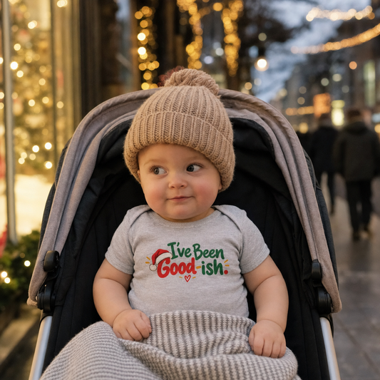 I've Been Good-ish baby bodysuit on a baby in a pram under Christmas lights